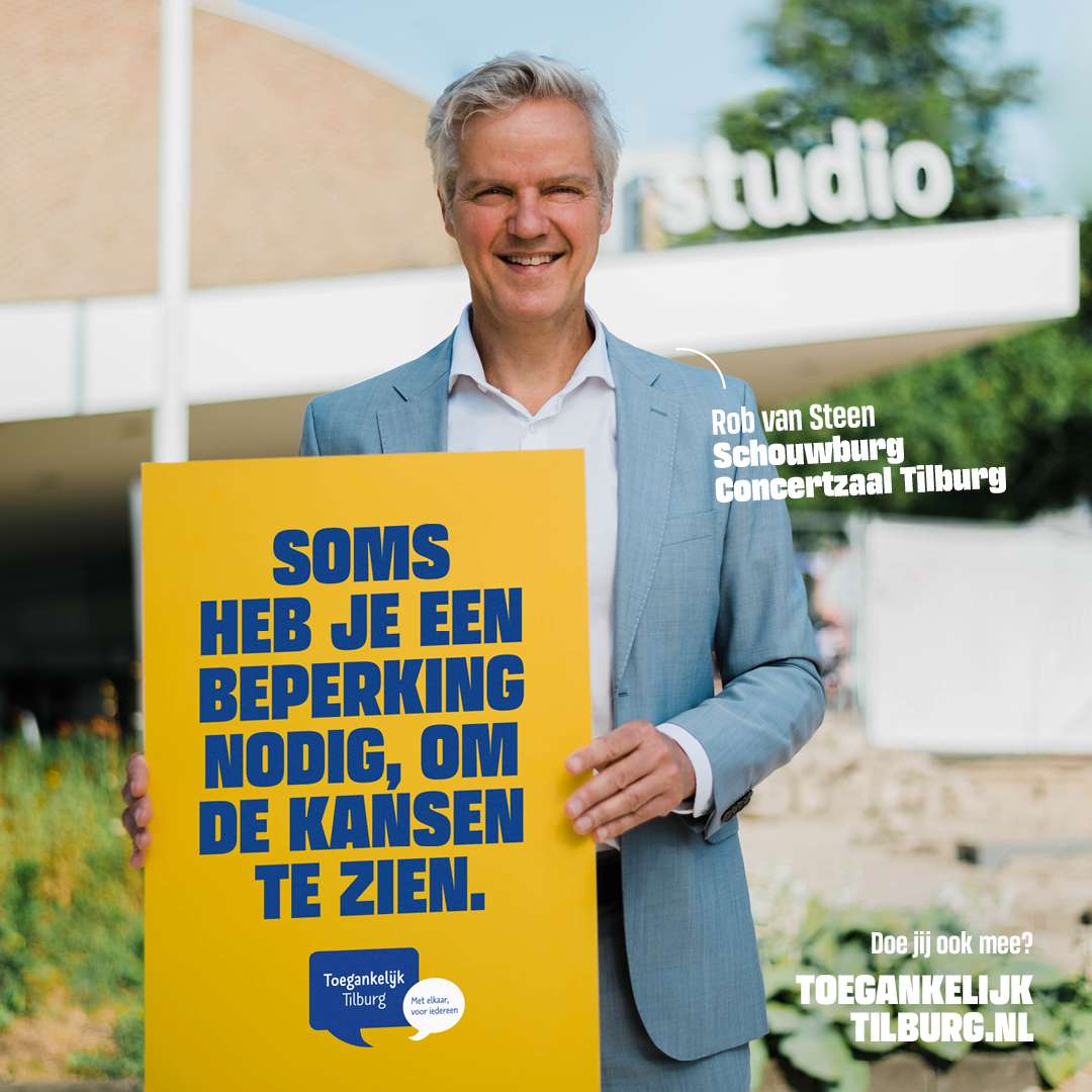 foto met Rob van Steen van Schouwburg en Concertzaal Tilburg met een groot bord voor zicht met de tekst: Soms heb je een beperking nodig, om kansen te zien. Toegankelijk Tilburg
