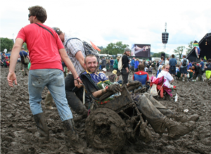 Vrienden trekken vriend in rolstoel door modder op festival